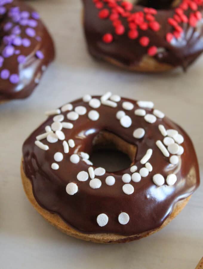 gluten free donut with chocolate glaze and white sprinkles.
