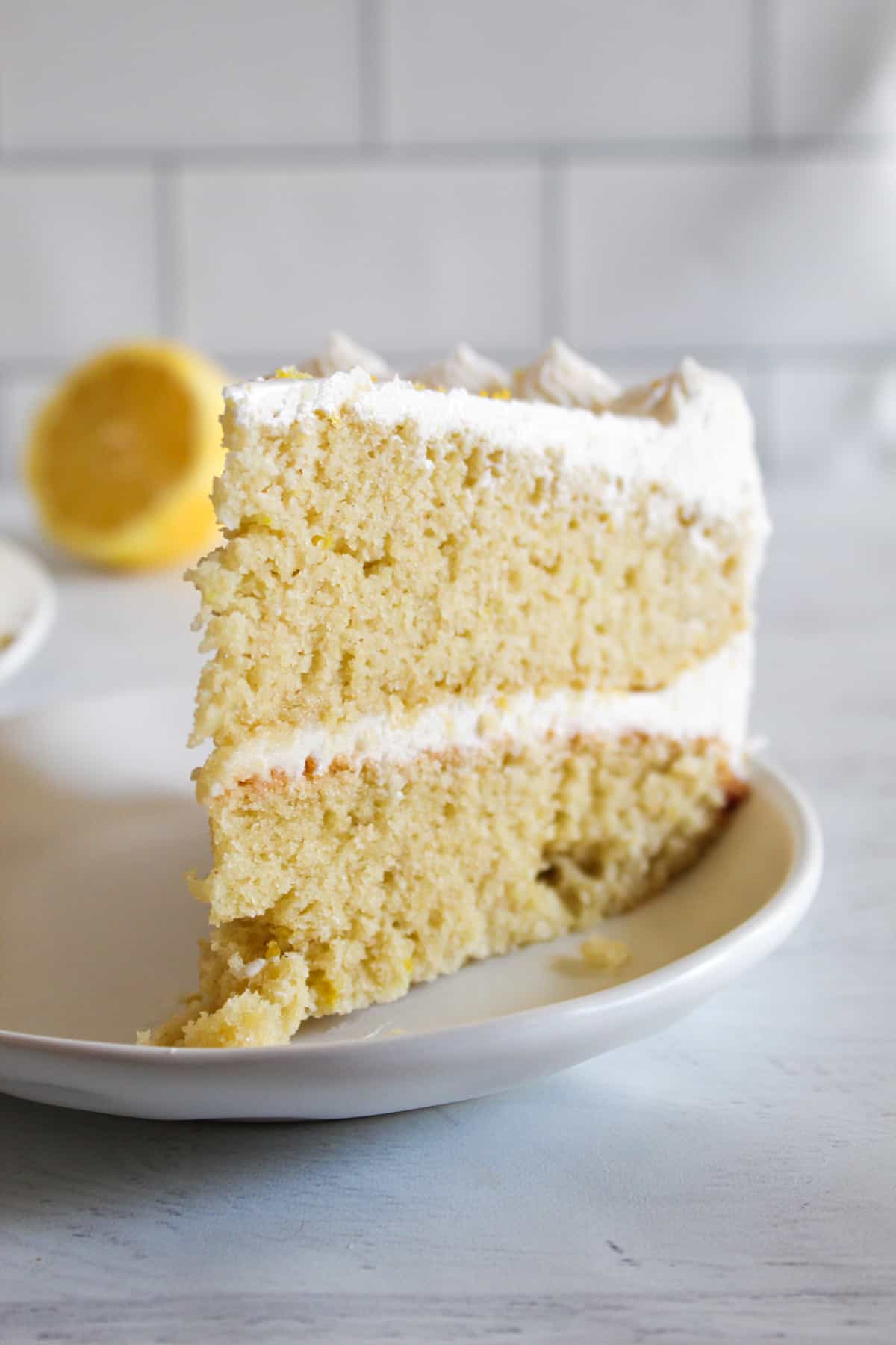 gluten free lemon cake slice on a white plate.