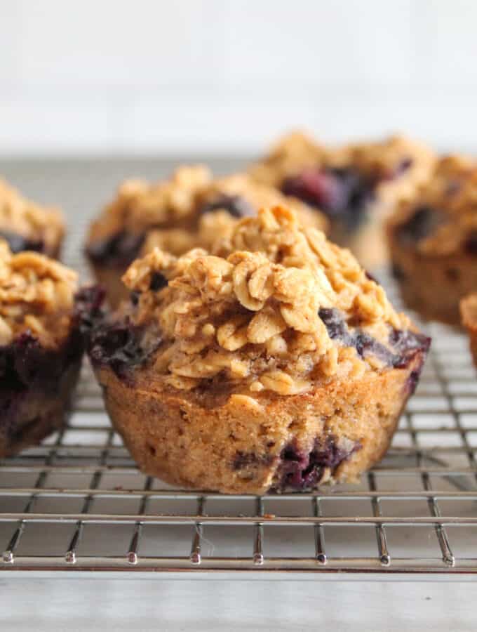 blueberry oatmeal muffin up close, on a wire rack.