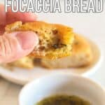 hand holding a piece of focaccia bread.
