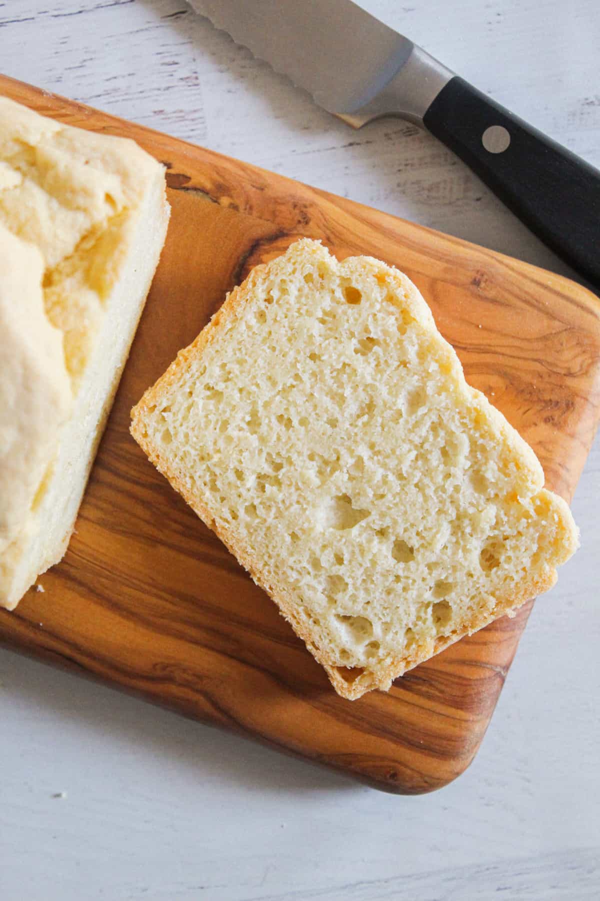 slice of gluten free yeast free bread on a cutting board.