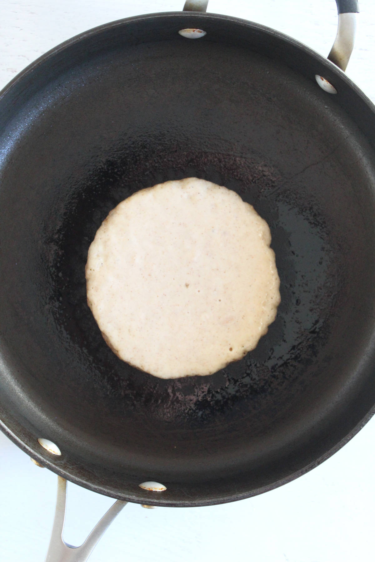 pancake batter cooking in a large skillet