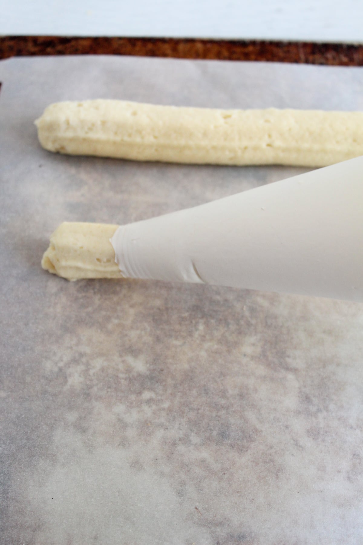 piping breadsticks on a pan.