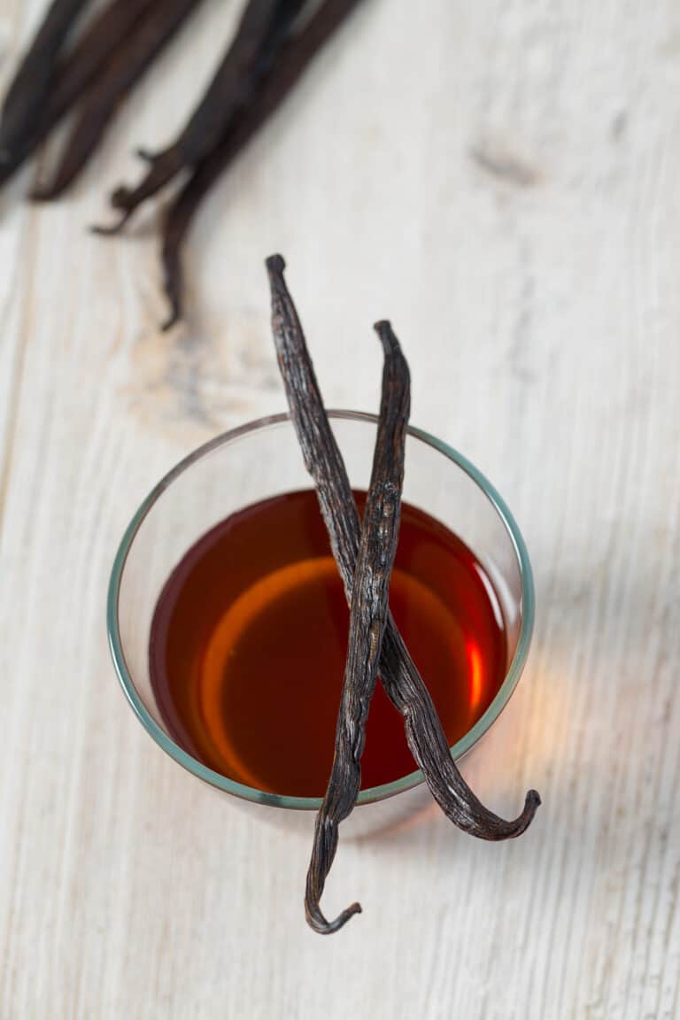 bowl of vanilla extract on a white counter.