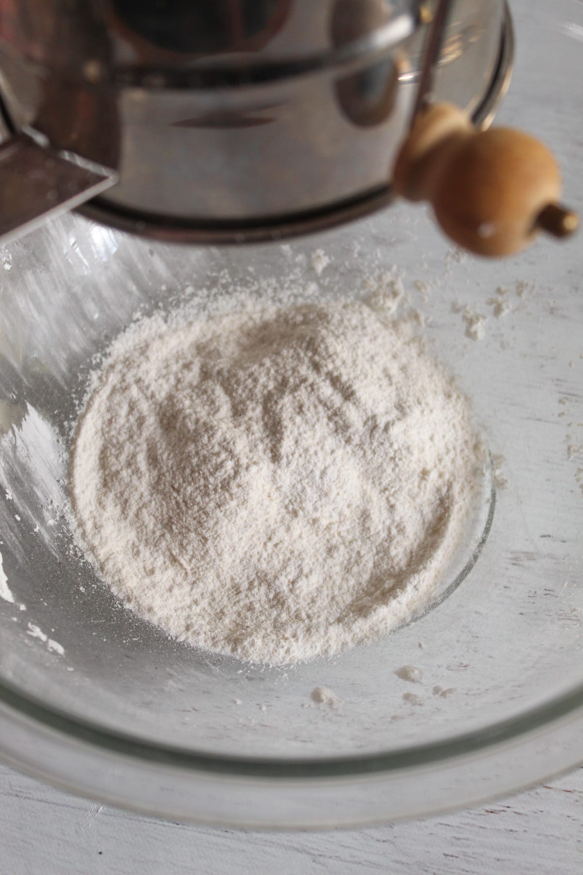 sifting gluten free flours in a glass bowl.