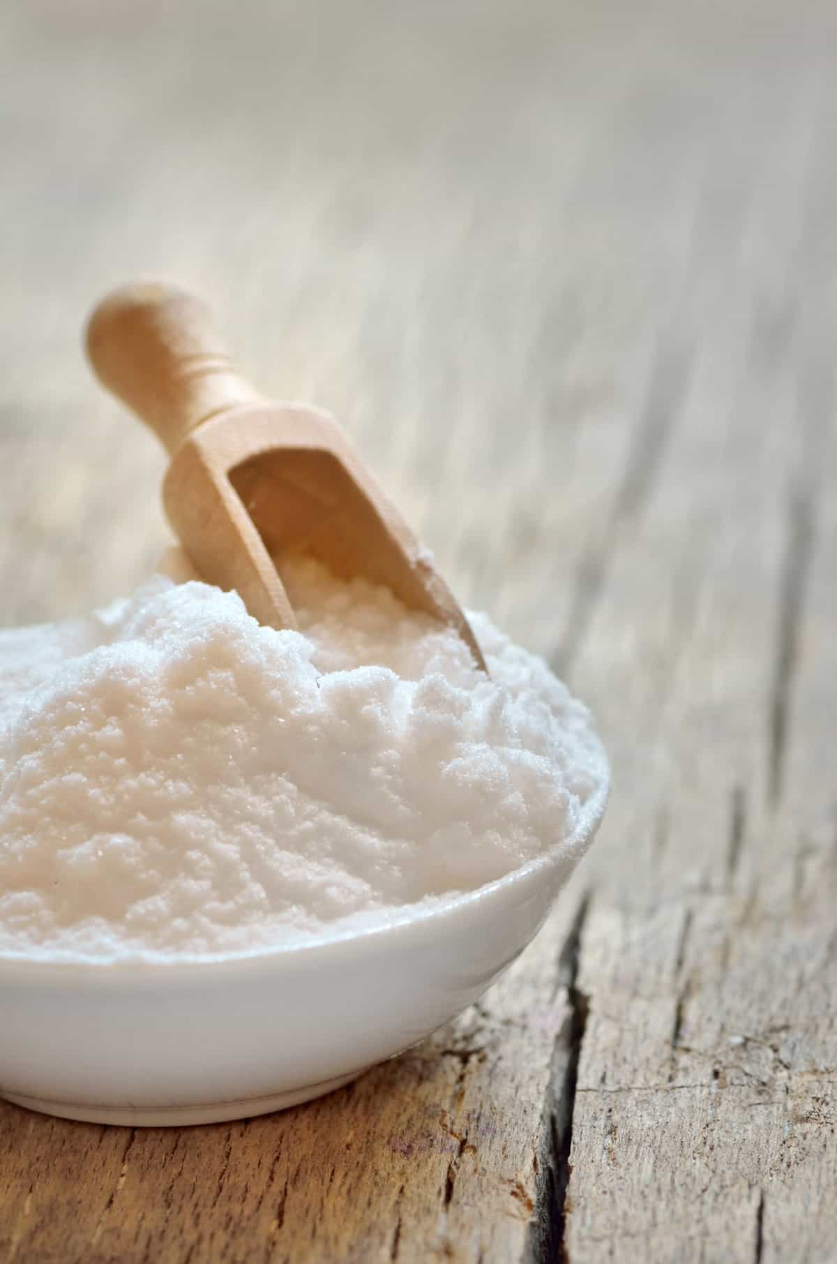 bowl of baking soda on a wooden table.