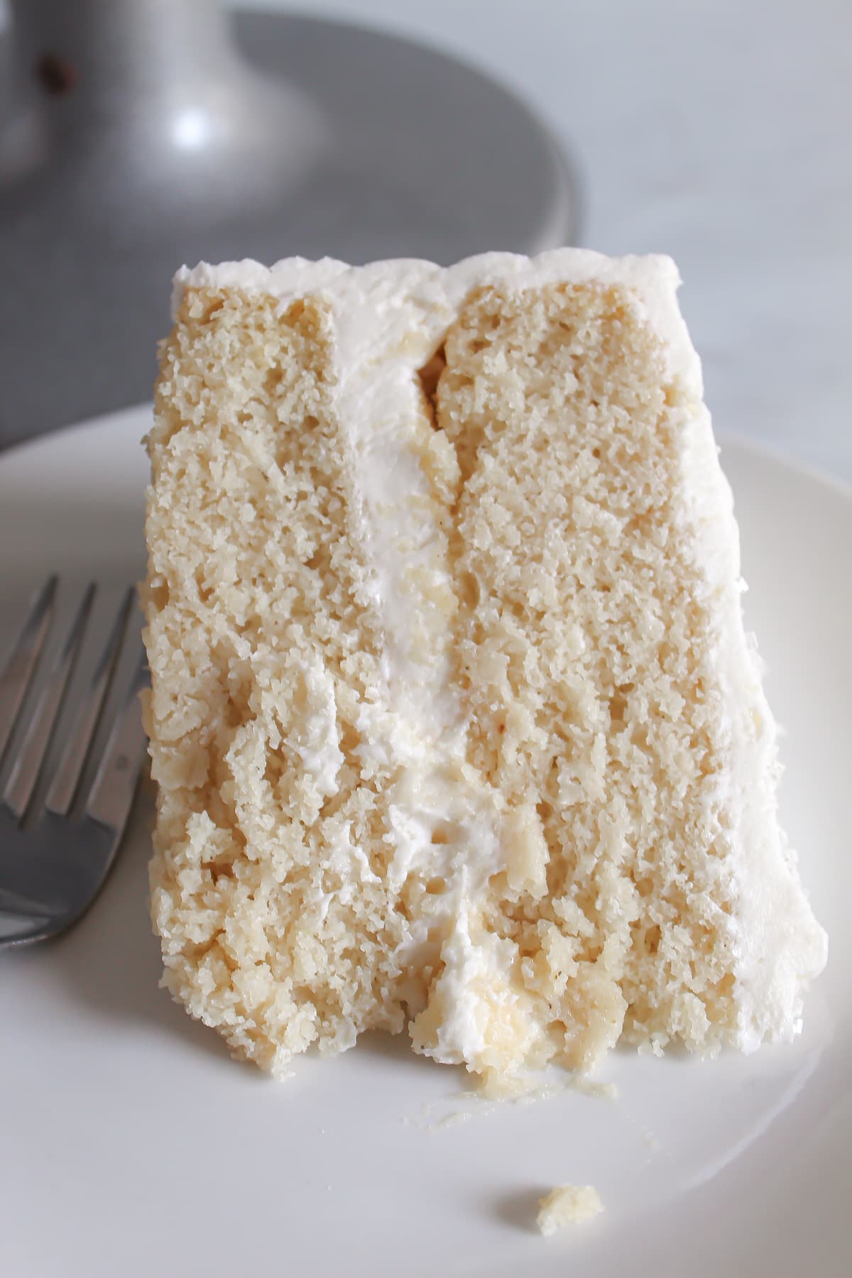 slice of gluten-free white cake with frosting.