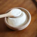 wooden bowl of xanthan gum with a spoon