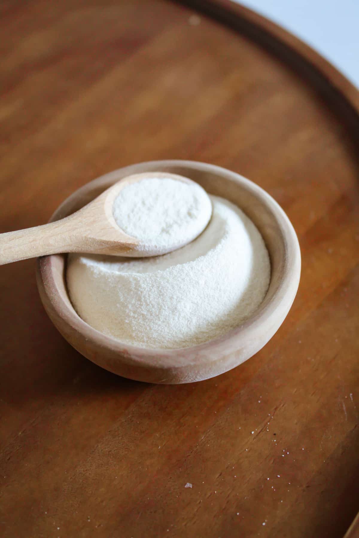 wooden bowl of xanthan gum with a spoon