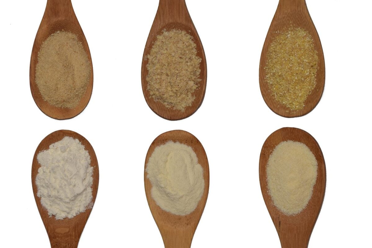 variety of grains, flours and powders on wooden spoons