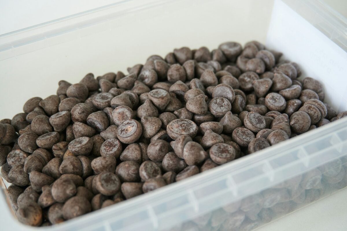 Dark chocolate drops in a plastic box for baking 85% cocoa