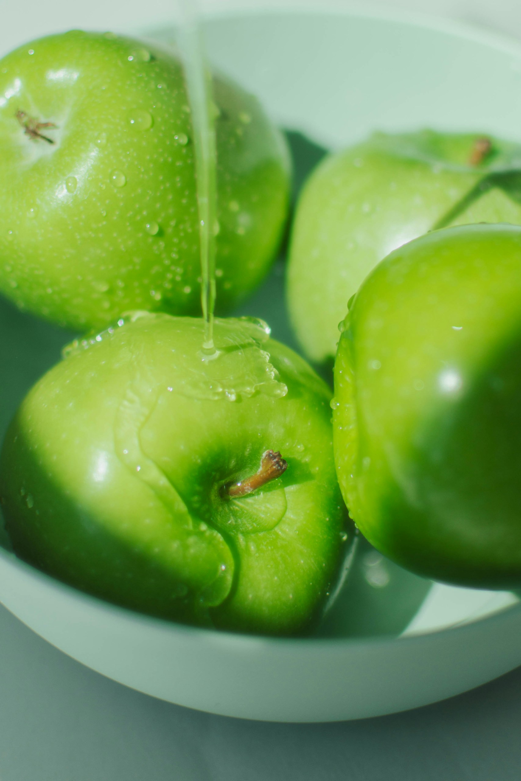 Green Apple under a running water for  applesauce egg replacement