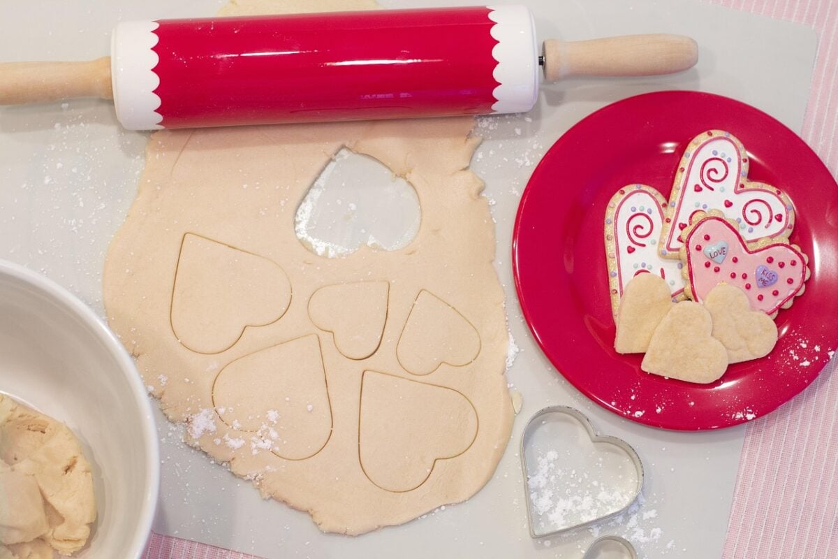 rolling and cutting out heart shaped cookies