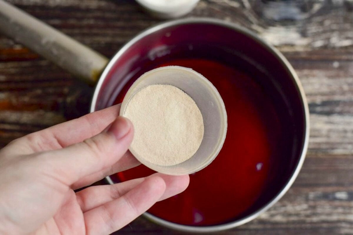 Agar powder in a cup above a pan of liquid.