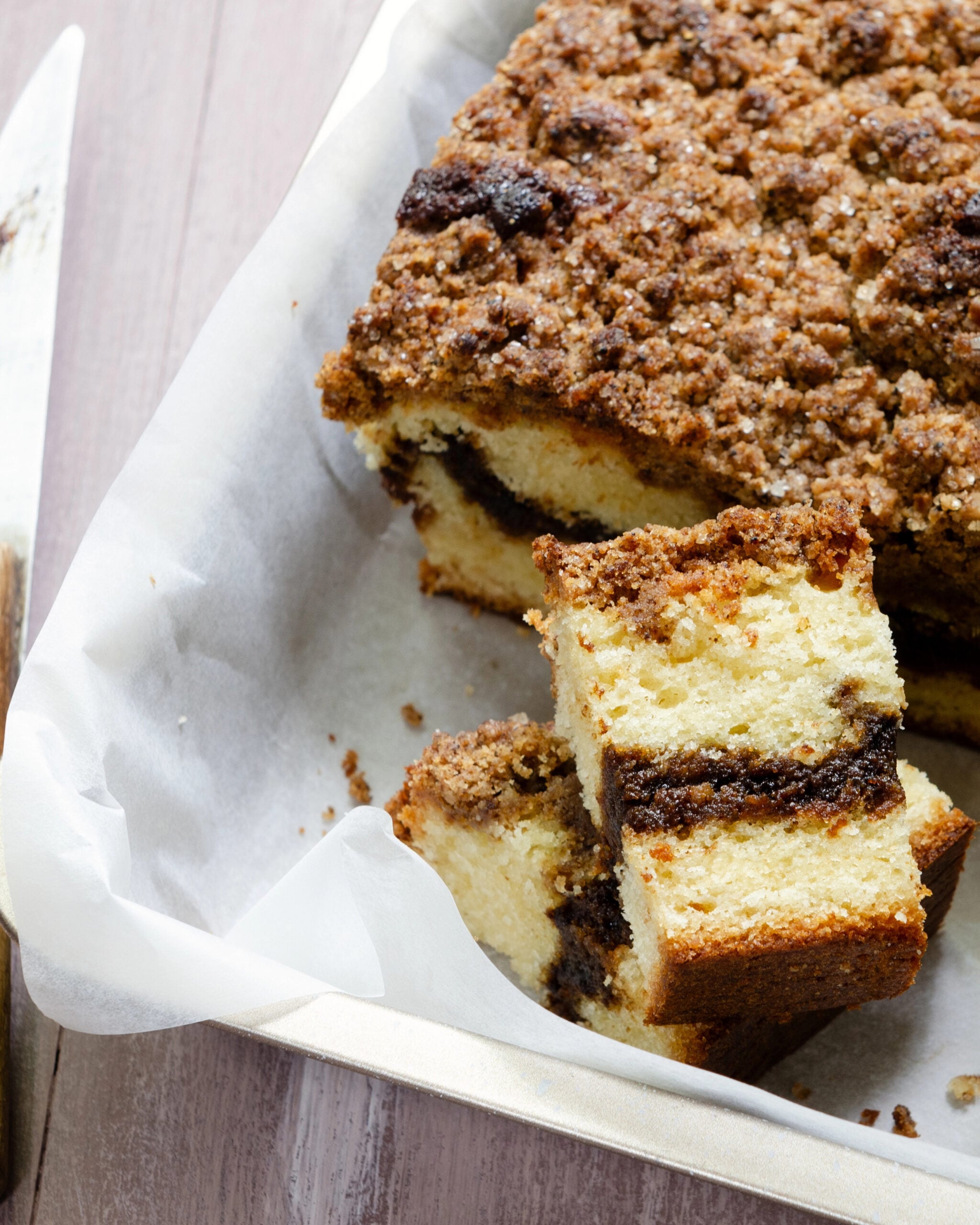 Close-up view of coffee cake has a ribbon of coffee filling and a crisp streusel topping.