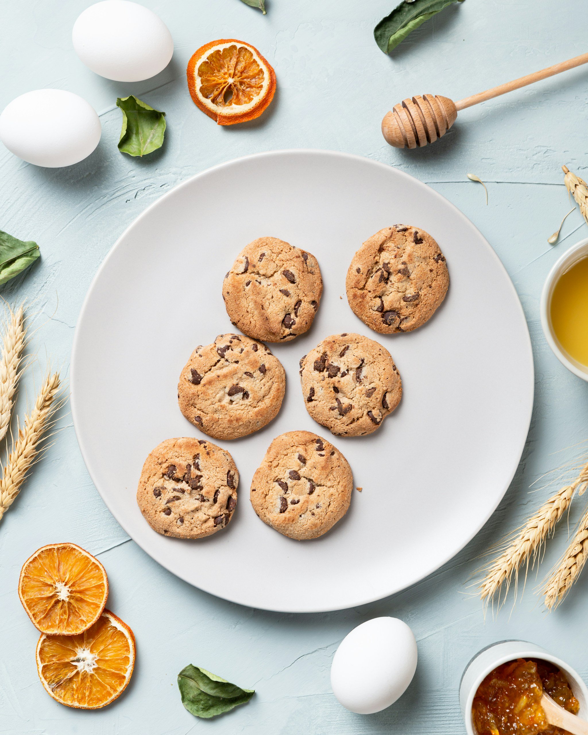 A plate of cookies with sliced oranges on the side with two eggs