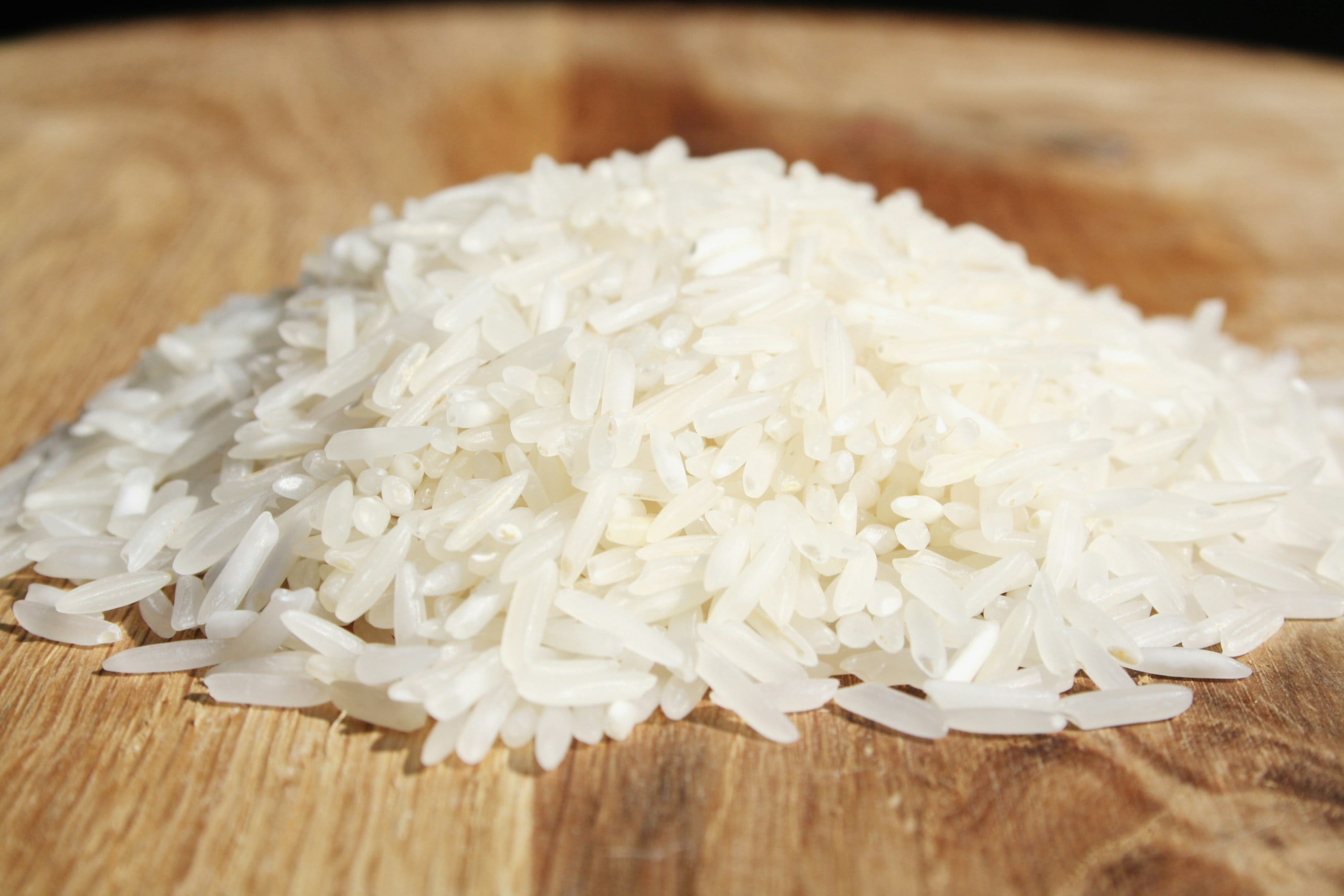 a pile of rice sitting on top of a wooden cutting board