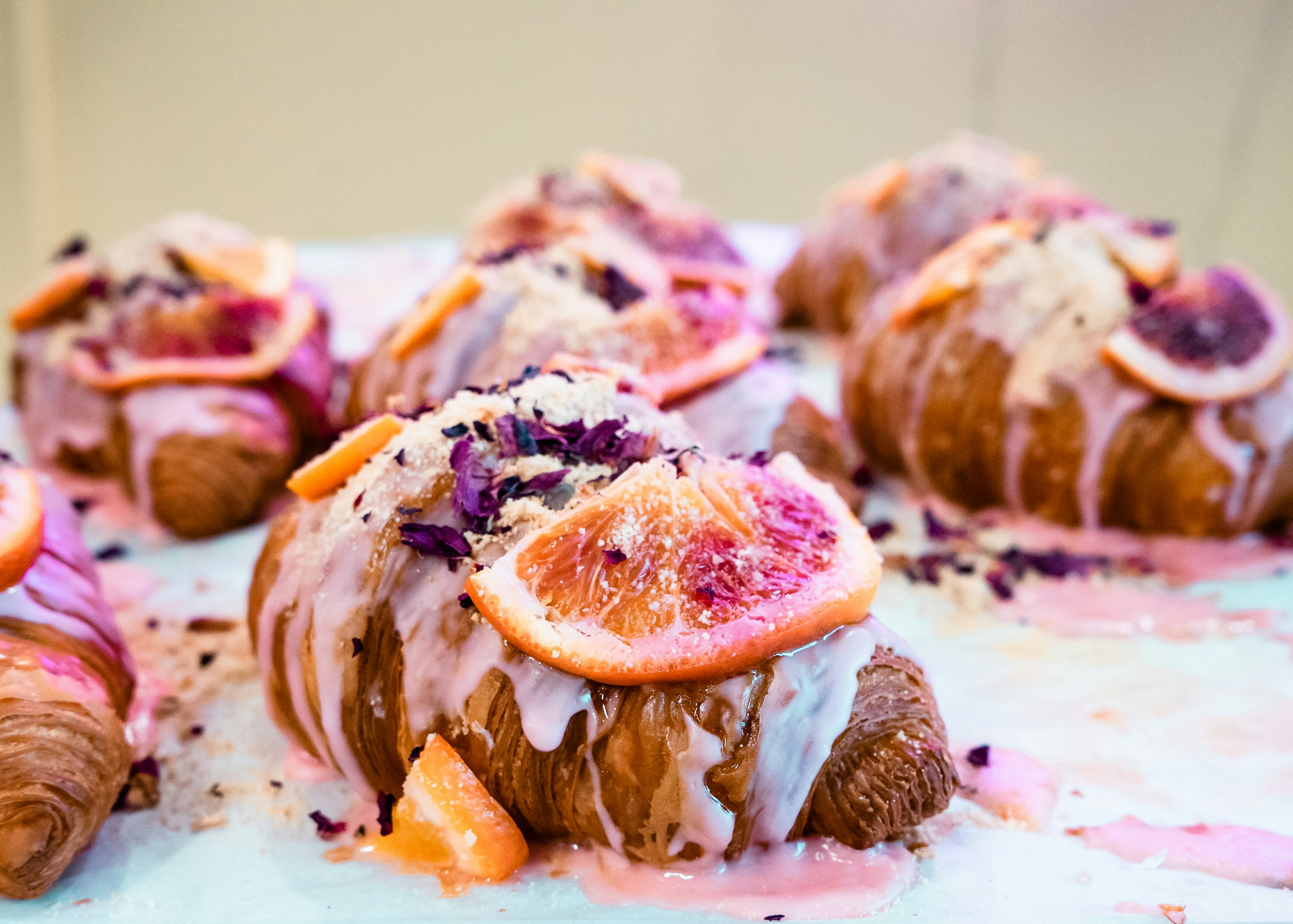 Blood orange filled croissants with pink icing and orange segments