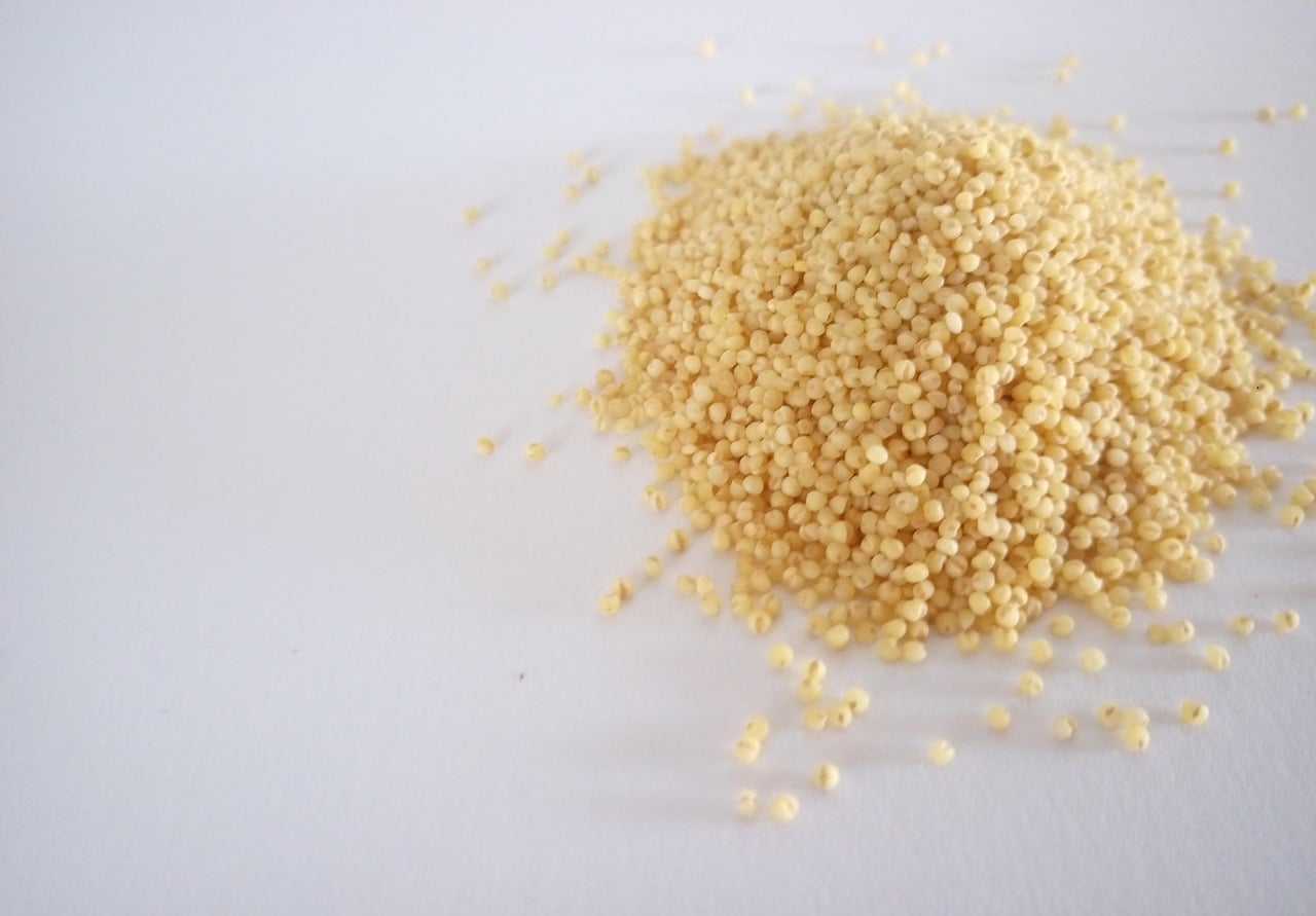 a pile of millet sitting on top of a wooden cutting board